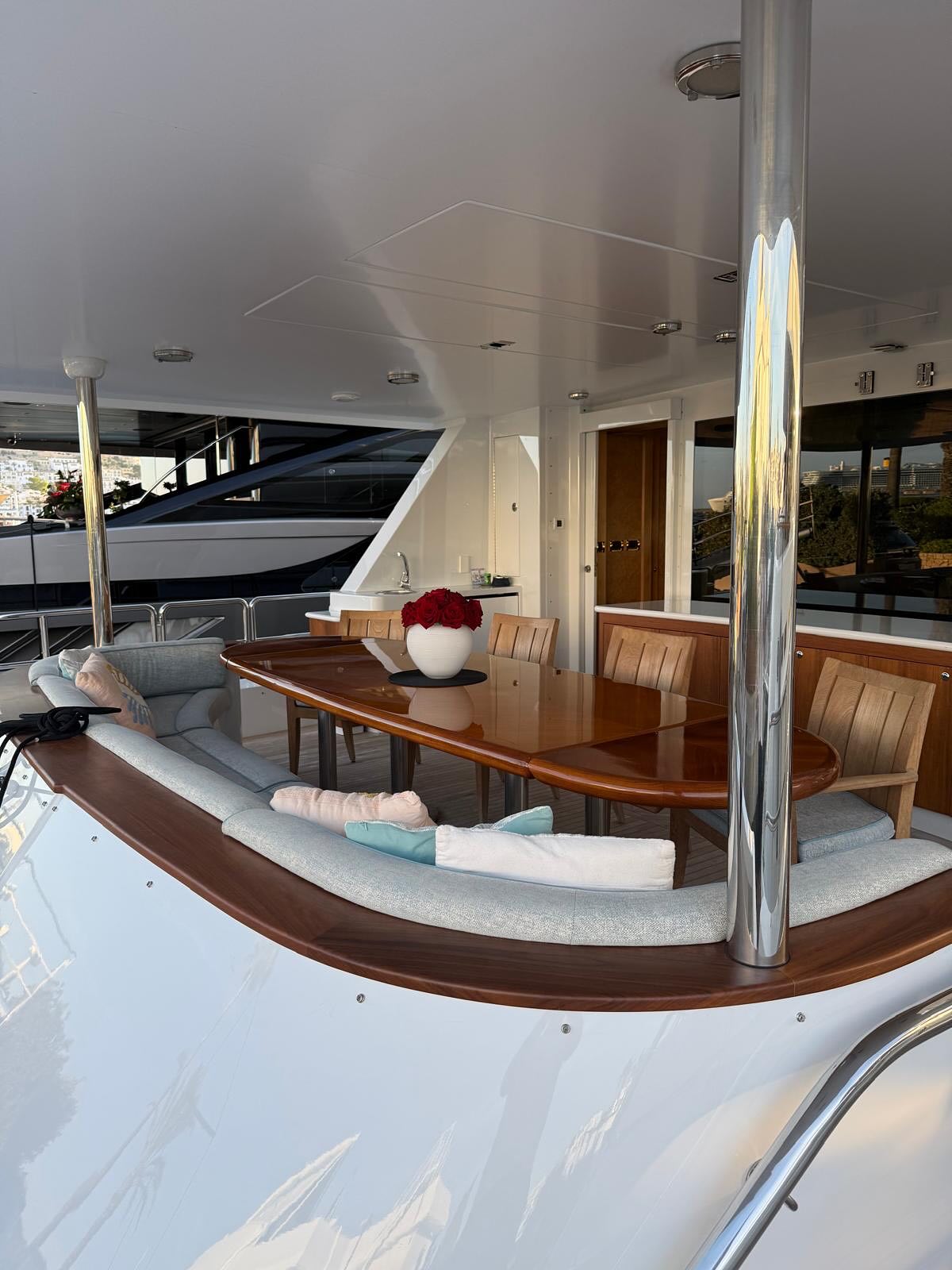 Varnished teak capping integrated around a motor yacht aft deck seating area