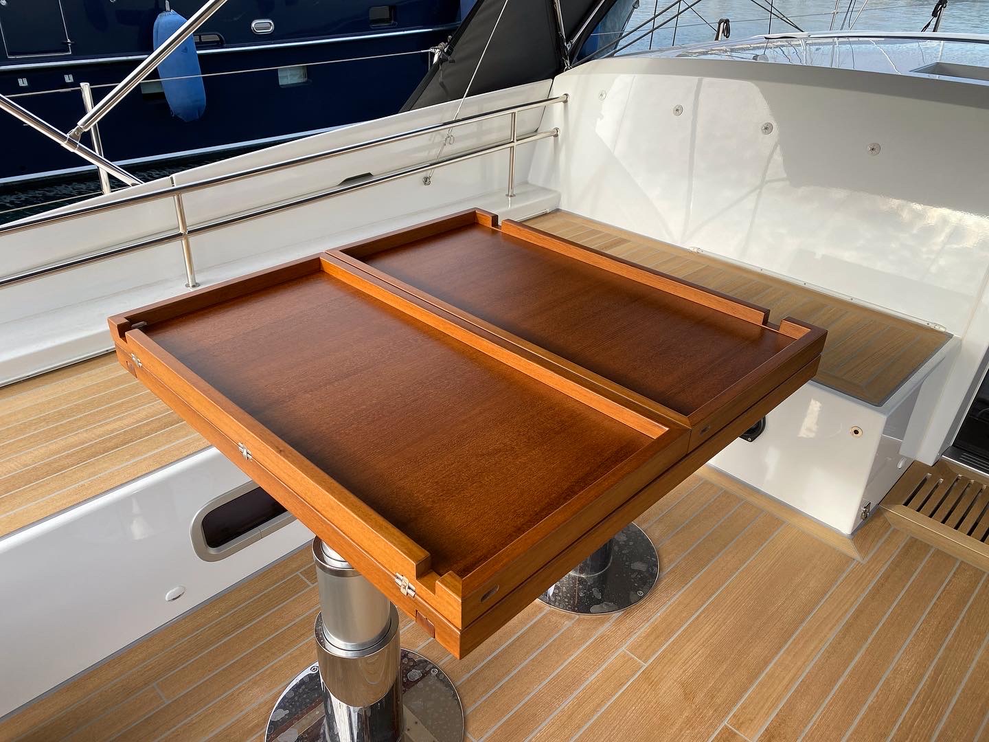 Restored yacht cockpit table configured with its raised serving rails