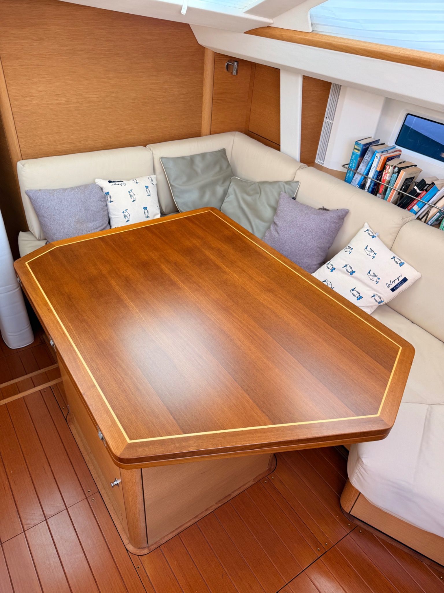 Bespoke varnished saloon table and fitted joinery inside a yacht
