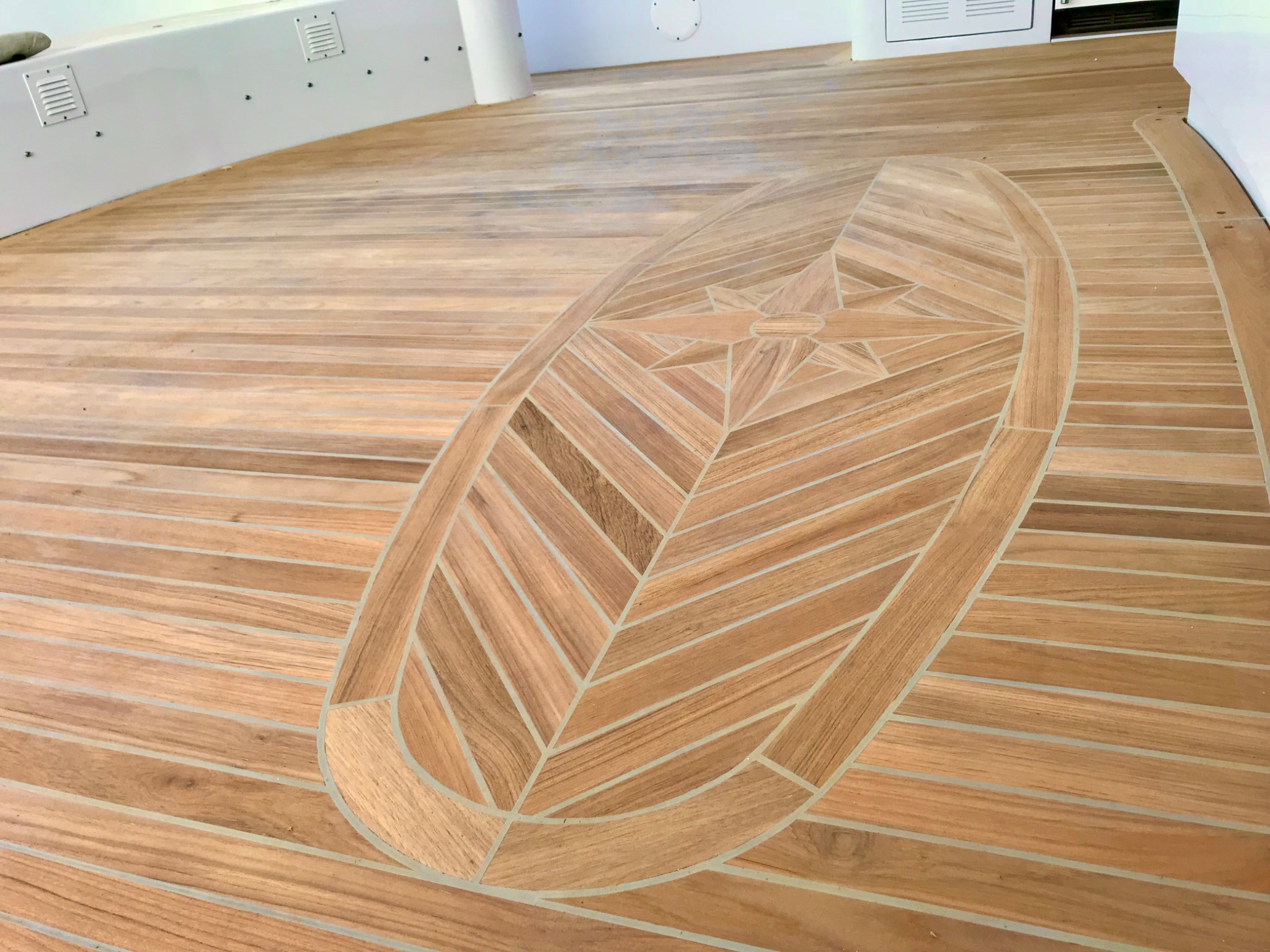 Custom teak yacht deck with an intricate compass rose inlay